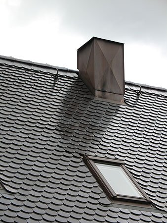 Dachumdeckung · Biberschwanzziegel · 18 x 38 Rundschnitt · Edelengobe kristallschwarz mit bekleidetem Schornstein in Kupfer