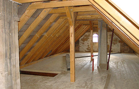 Zugerichteter und aufgestellter Dachstuhl auf altem Gebäude, einschließlich neuem Dielenboden