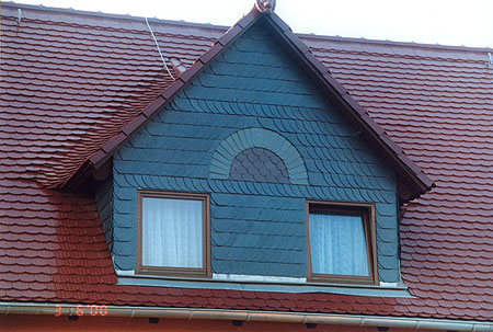 Wandbekleidung aus Naturschiefer mit farbigen Schmuckelementen