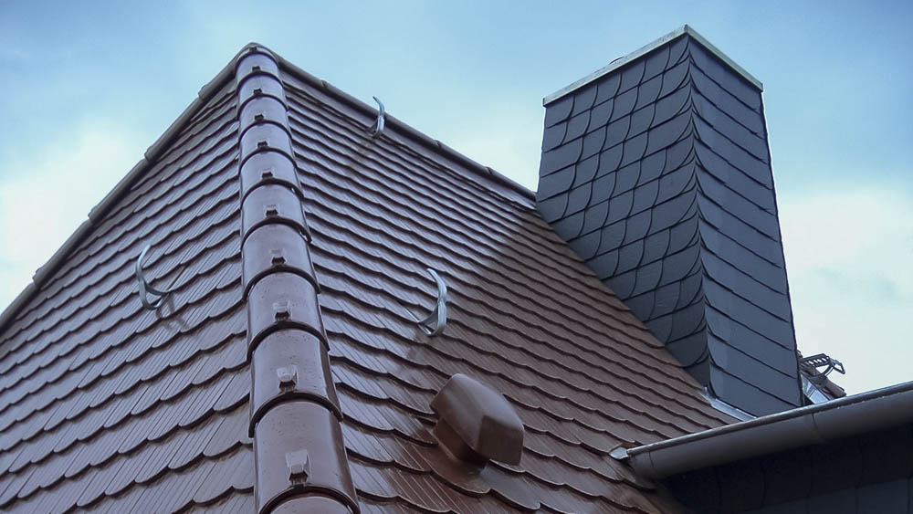 Schornsteinbau Steildach mit Biberschwanzeindeckung und mit Schiefer verkleidetem Schornstein