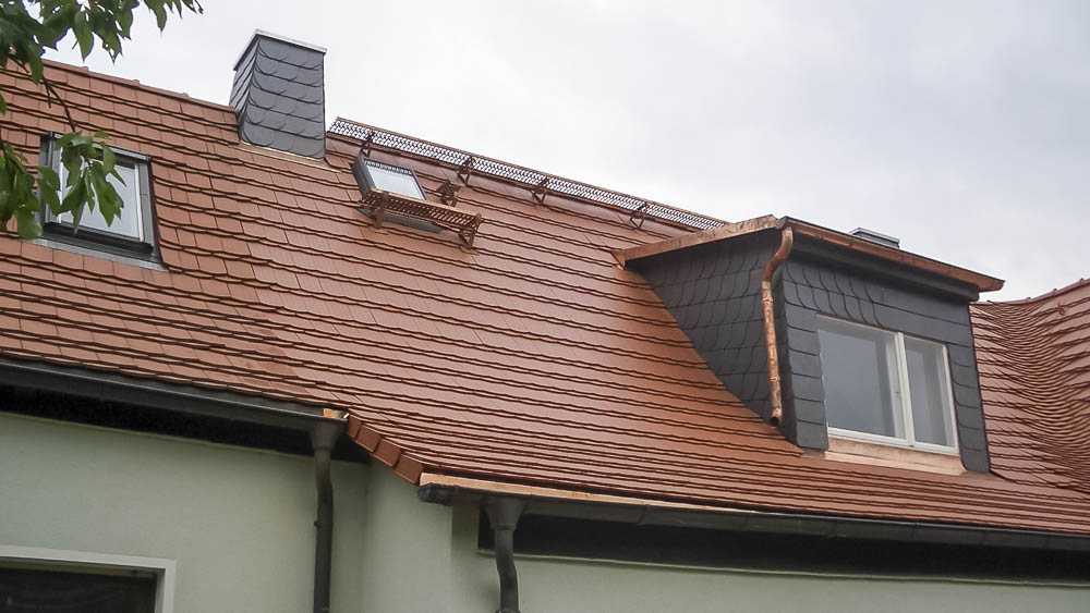 Biberschwanzeindeckung mit eingebundener Kehle Rotes Biberschwanzdach mit Gaube und eingebundener Kehle