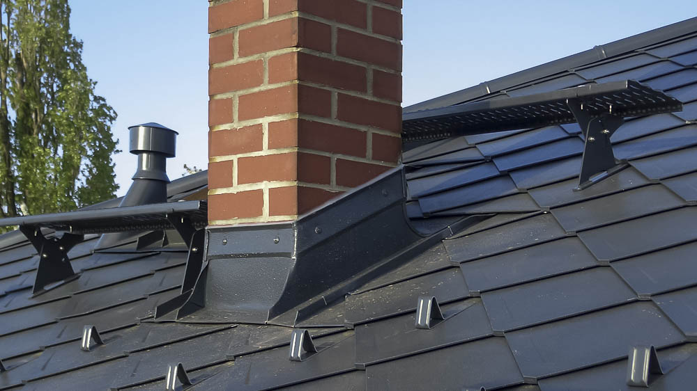 Dacheindeckung mit Prefa-Dachraute und gefalzter Schornsteineinfassung Schornsteineinfassung auf Blechdach