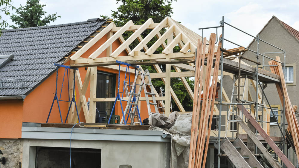 Passgenauer Hausanbau in Holz Im Bau befindliche Holzkonstruktion für einen Anbau an einem Wohnhaus